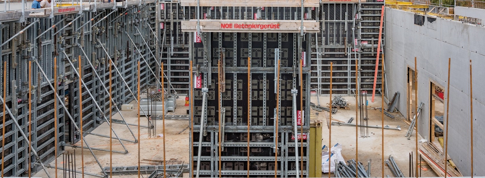 Großflächige Baustelle mit Wandschalungen und gestapeltem Schalungsmaterial aus dem NOE‑Mietpark.